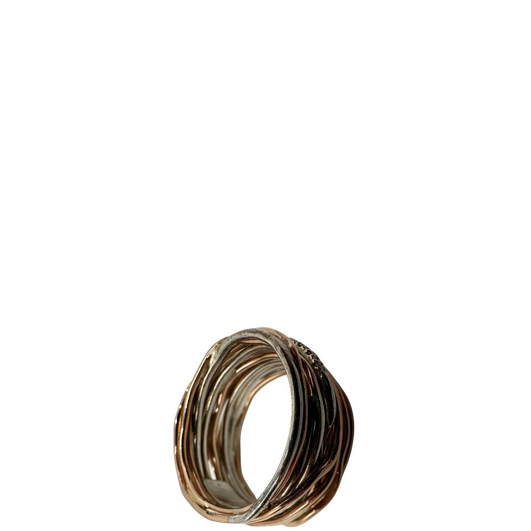 Tredici fili in oro rosa 9kt e argento 925 arricchito al palladio intrecciati, sulla cui superficie risplendono sedici diamanti bianchi taglio brillante da 0.21 ct. Completo di scatola, di lusso, originale, ottime condizioni, usato.