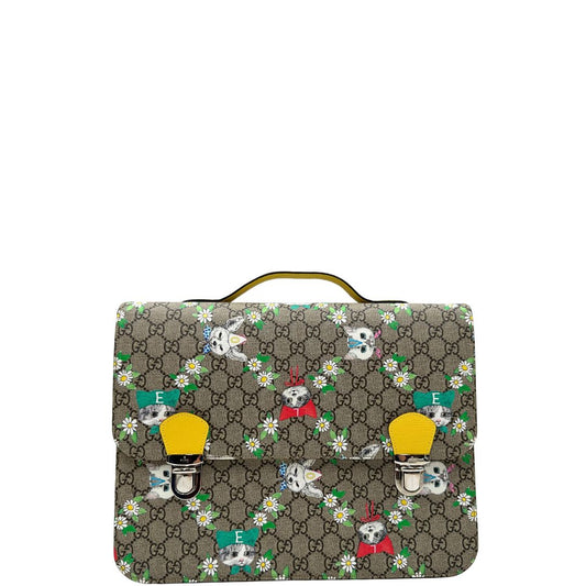 Front di uno zaino Gucci Kids in canvas monogram GG beige con stampa floreale e animaletti; finiture e interno in pelle gialla. Chiusura a patta con doppi ganci e parti metalliche argentate; dotato di manico superiore e doppie bretelle regolabili in tessuto verde oliva con ricami a farfalle fucsia. Completo di scatola e dustbag.