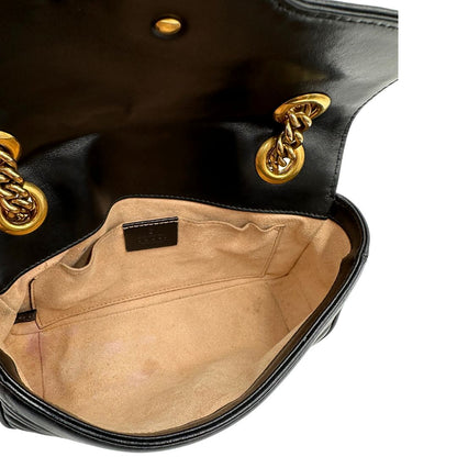 Interno di una borsa Gucci Marmont in pelle matelassè nera e parti metalliche dorate; munita di una tracolla in catena scorrevole con spallaccio in pelle. Dotata di scatola. Indossabile a spalla e a tracolla.