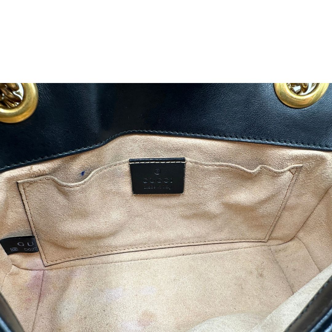 Interno di una borsa Gucci Marmont in pelle matelassè nera e parti metalliche dorate; munita di una tracolla in catena scorrevole con spallaccio in pelle. Dotata di scatola. Indossabile a spalla e a tracolla.