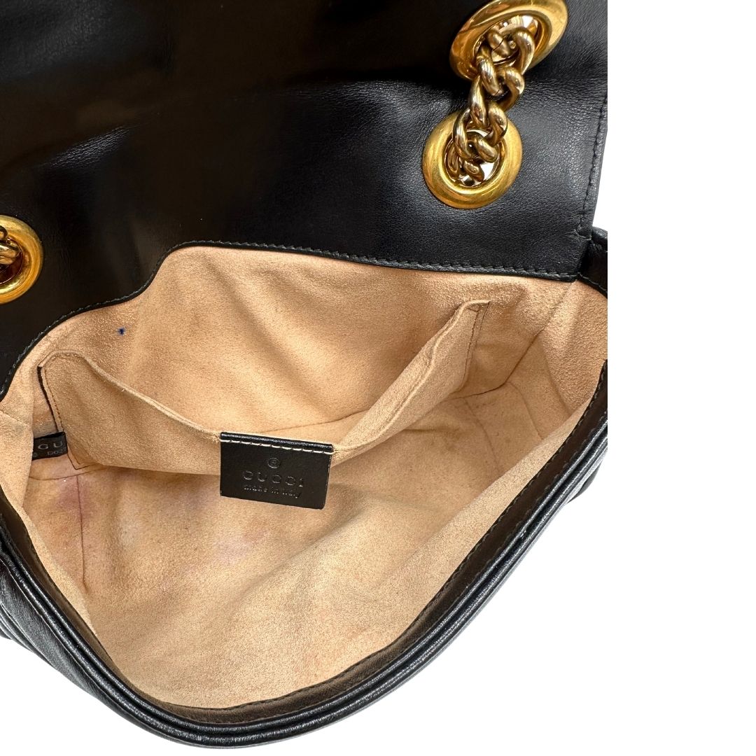Interno di una borsa Gucci Marmont in pelle matelassè nera e parti metalliche dorate; munita di una tracolla in catena scorrevole con spallaccio in pelle. Dotata di scatola. Indossabile a spalla e a tracolla.
