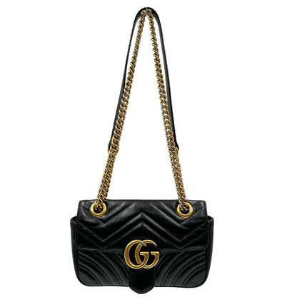 Front di una borsa Gucci Marmont in pelle matelassè nera e parti metalliche dorate; munita di una tracolla in catena scorrevole con spallaccio in pelle. Dotata di scatola. Indossabile a spalla e a tracolla.