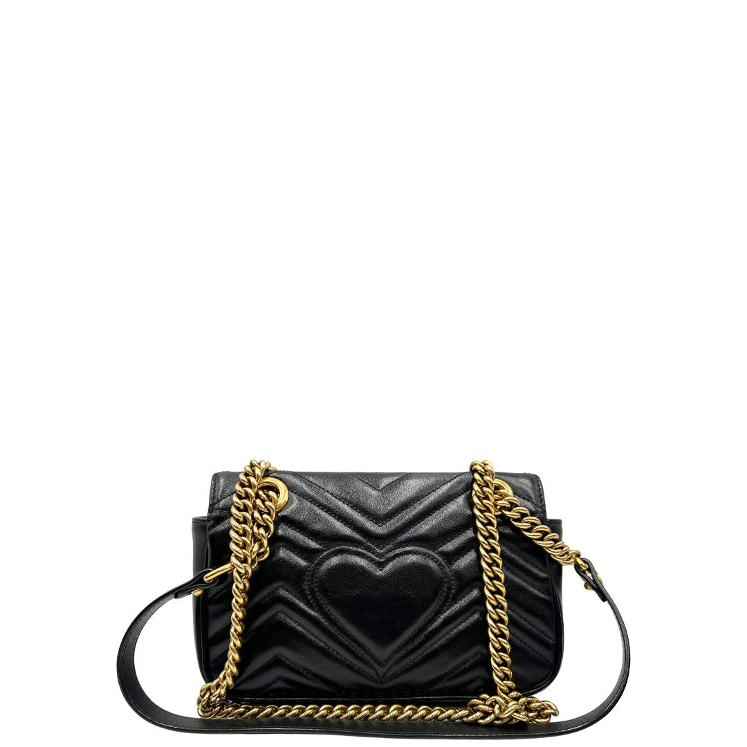 Retro di una borsa Gucci Marmont in pelle matelassè nera e parti metalliche dorate; munita di una tracolla in catena scorrevole con spallaccio in pelle. Dotata di scatola. Indossabile a spalla e a tracolla.