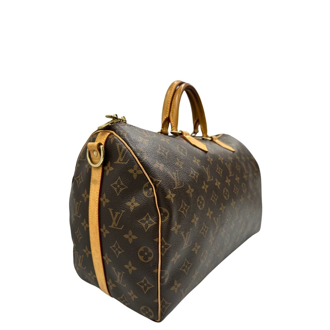 lato Borsa Louis Vuitton in canvas marrone monogram con finiture in vacchetta naturale e parti metalliche dorate; munita di doppi manici stondati. Completa di lucchetto e chiavi, di lusso, originale, ottime condizioni, usato. 