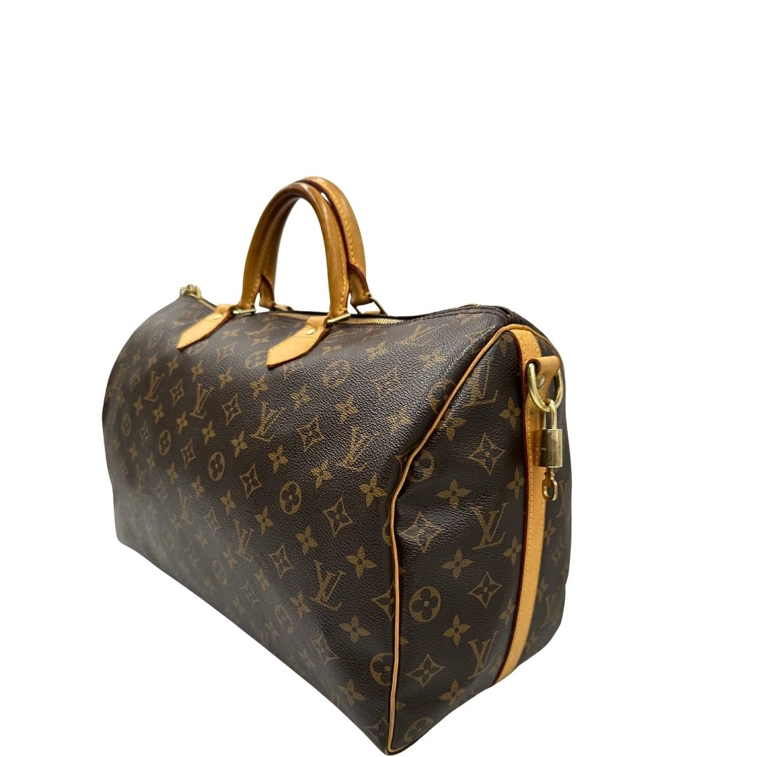 lato Borsa Louis Vuitton in canvas marrone monogram con finiture in vacchetta naturale e parti metalliche dorate; munita di doppi manici stondati. Completa di lucchetto e chiavi, di lusso, originale, ottime condizioni, usato. 