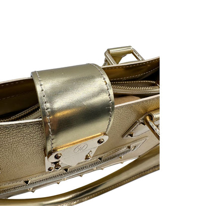 Chiusura di una borsa Louis Vuitton Suhali Le Fabuleux in pelle color oro con parti metalliche dorate. Munita di doppi manici stondati, impreziosita da una clochette porta chiavi. Completa di scatola e dustbag.