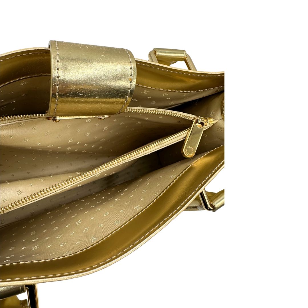 Interno di una borsa Louis Vuitton Suhali Le Fabuleux in pelle color oro con parti metalliche dorate. Munita di doppi manici stondati, impreziosita da una clochette porta chiavi. Completa di scatola e dustbag.