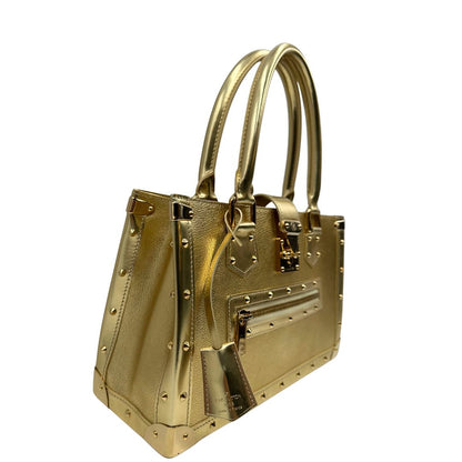 Laterale sinistro di una borsa Louis Vuitton Suhali Le Fabuleux in pelle color oro con parti metalliche dorate. Munita di doppi manici stondati, impreziosita da una clochette porta chiavi. Completa di scatola e dustbag.