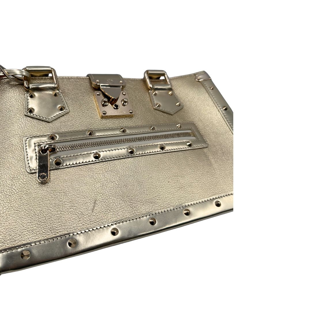 Difetto di una borsa Louis Vuitton Suhali Le Fabuleux in pelle color oro con parti metalliche dorate. Munita di doppi manici stondati, impreziosita da una clochette porta chiavi. Completa di scatola e dustbag.