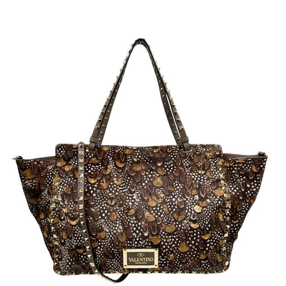 Retro di una Borsa Prada effetto cavallino stampato con piume multicolore e finiture in pelle marrone, con parti metalliche dorate; impreziosita da borchie piramidali e munita di doppi manici e tracolla amovibile. Completa di dustbag. Originale, usata, di lusso, in ottime condizioni.