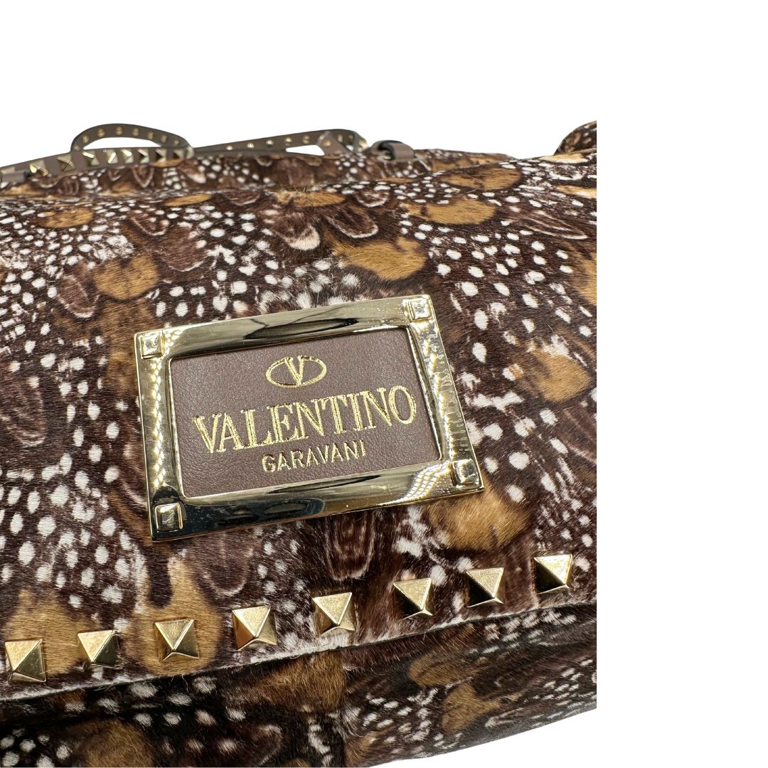 Borsa Prada effetto cavallino stampato con piume multicolore e finiture in pelle marrone, con parti metalliche dorate; impreziosita da borchie piramidali e munita di doppi manici e tracolla amovibile. Completa di dustbag. Originale, usata, di lusso, in ottime condizioni.