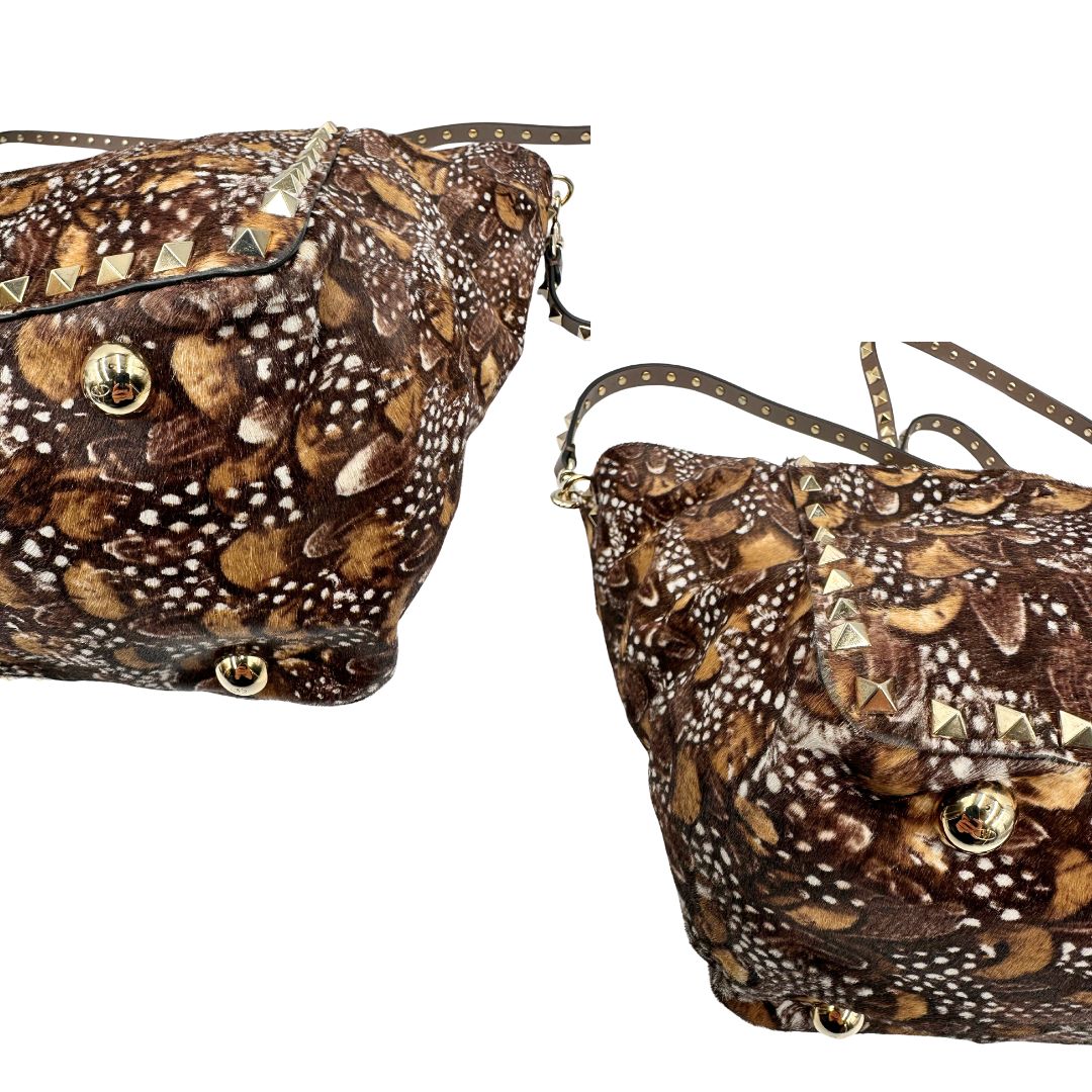 Angoli di una Borsa Prada effetto cavallino stampato con piume multicolore e finiture in pelle marrone, con parti metalliche dorate; impreziosita da borchie piramidali e munita di doppi manici e tracolla amovibile. Completa di dustbag. Originale, usata, di lusso, in ottime condizioni.