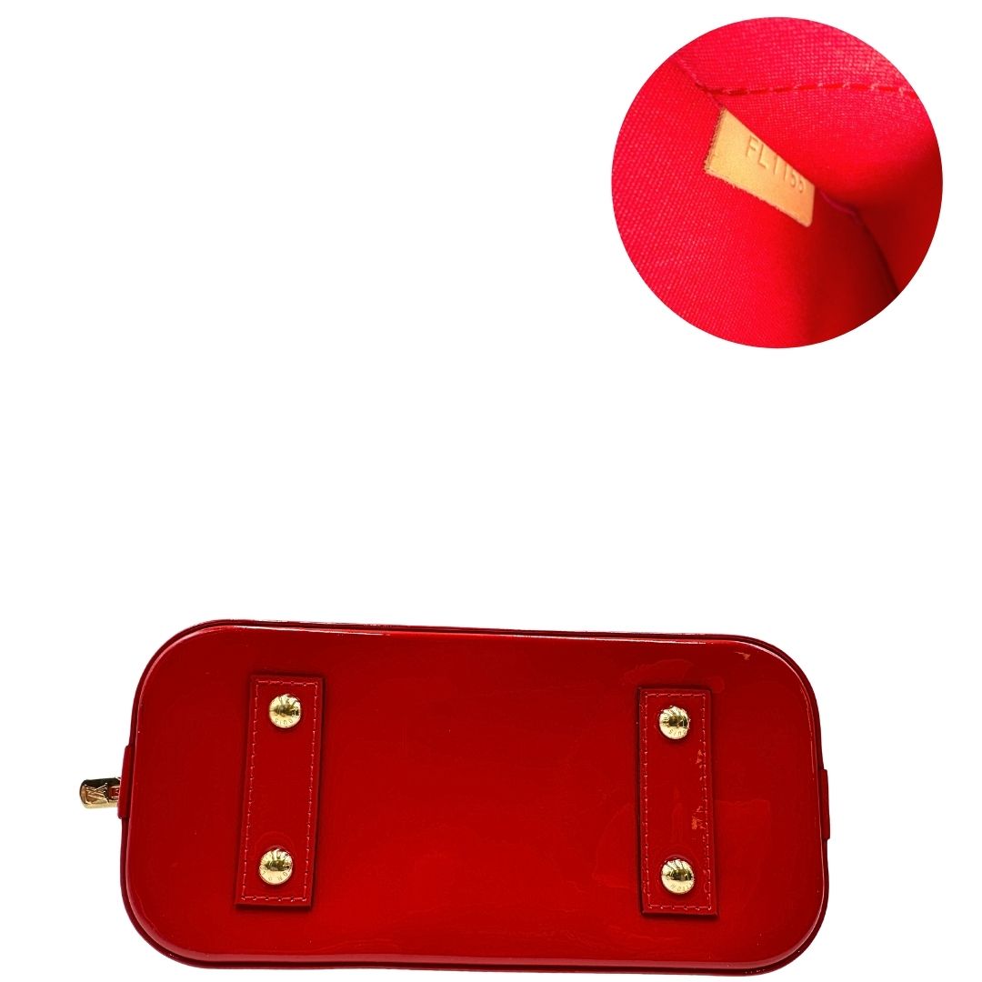 Base e codice di una borsa Louis Vuitton Alma BB in pelle vernis rossa con trama monogram empreinte e parti metalliche dorate. Munita di doppi manici stondati e tracolla amovibile, dotata di clochette porta chiavi. Completa di scatola, dustbag, lucchetto e chiavi.