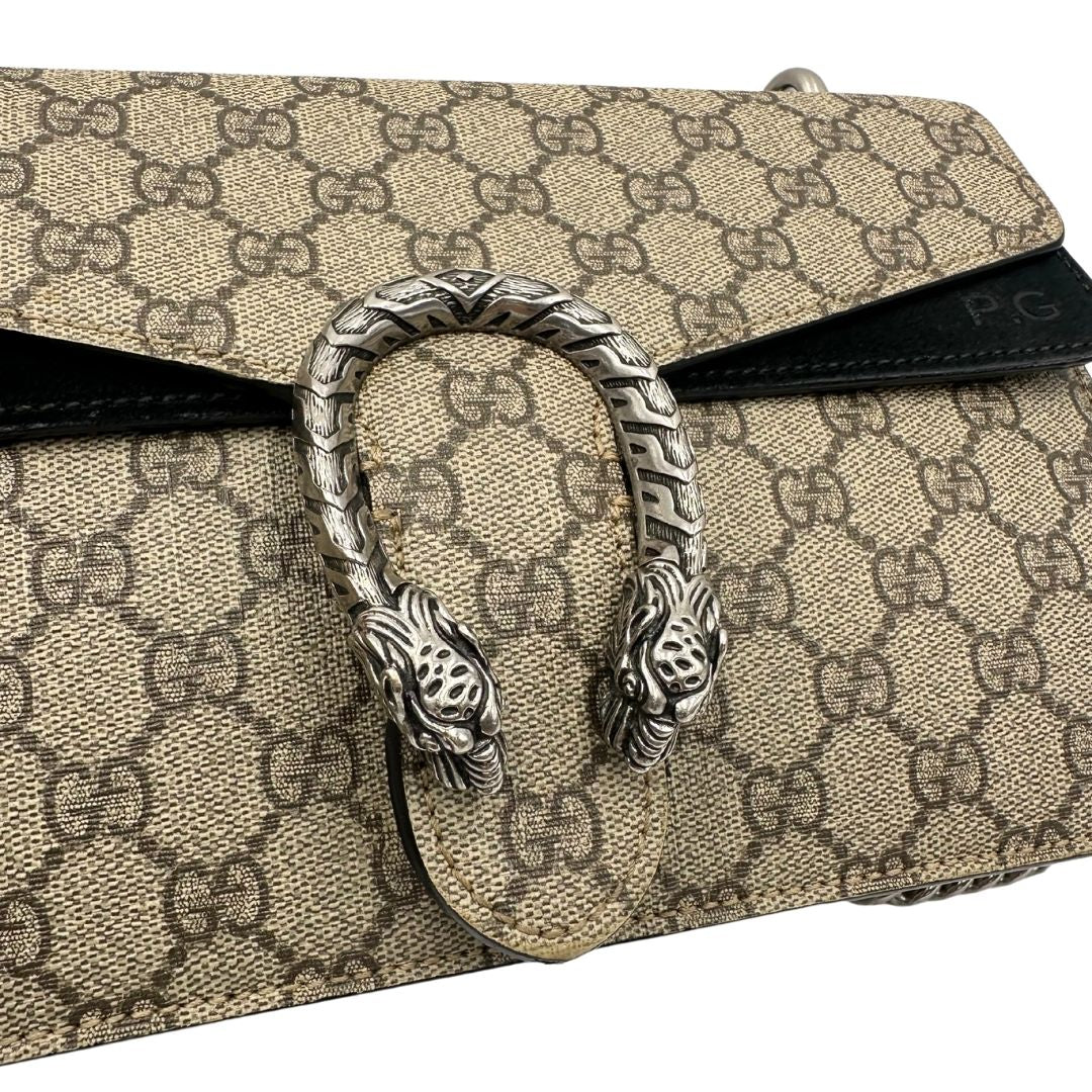 Chiusura di una Borsa Gucci in canvas beige monogram GG, finiture in pelle scamosciata nera e parti metalliche argentate; munita di una tracolla in catena scorrevole. Indossabile a spalla oppure a tracolla. Originale, usata, di lusso, in ottime condizioni.