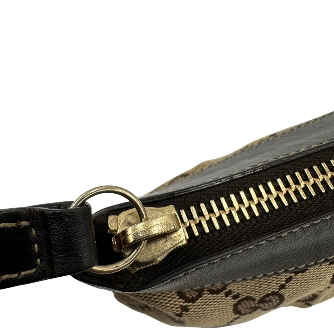 Cerniera di una pochette Gucci in tessuto Gucci in tessuto GG beige con finiture in pelle marrone e parti metalliche dorate; munita di un polsino, da portare a mano. Completa di dustbag.