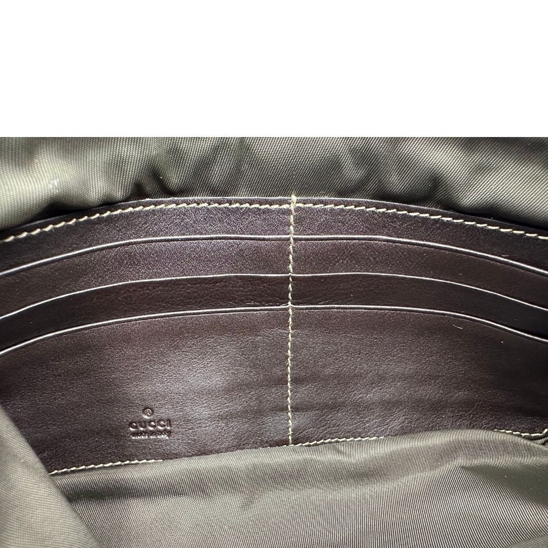 Interno di una pochette Gucci in tessuto Gucci in tessuto GG beige con finiture in pelle marrone e parti metalliche dorate; munita di un polsino, da portare a mano. Completa di dustbag.