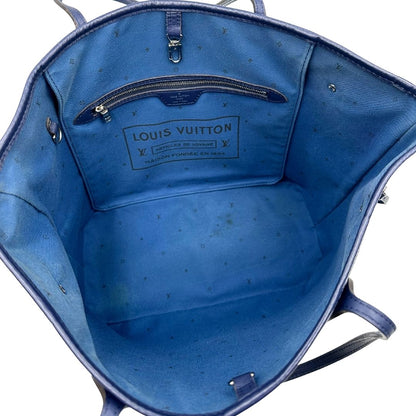 Interno di una borsa Louis Vuitton Neverfull MM in canvas base tie-dye nelle tonalità del blu e bianco, con finiture in pelle blu navy. Da un lato ha stampa Monogram Giant, dall'altra Monogram. Parti metalliche argentate; munita di doppi manici e dustbag, indossabile a spalla.