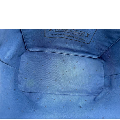 Interno di una borsa Louis Vuitton Neverfull MM in canvas base tie-dye nelle tonalità del blu e bianco, con finiture in pelle blu navy. Da un lato ha stampa Monogram Giant, dall'altra Monogram. Parti metalliche argentate; munita di doppi manici e dustbag, indossabile a spalla.