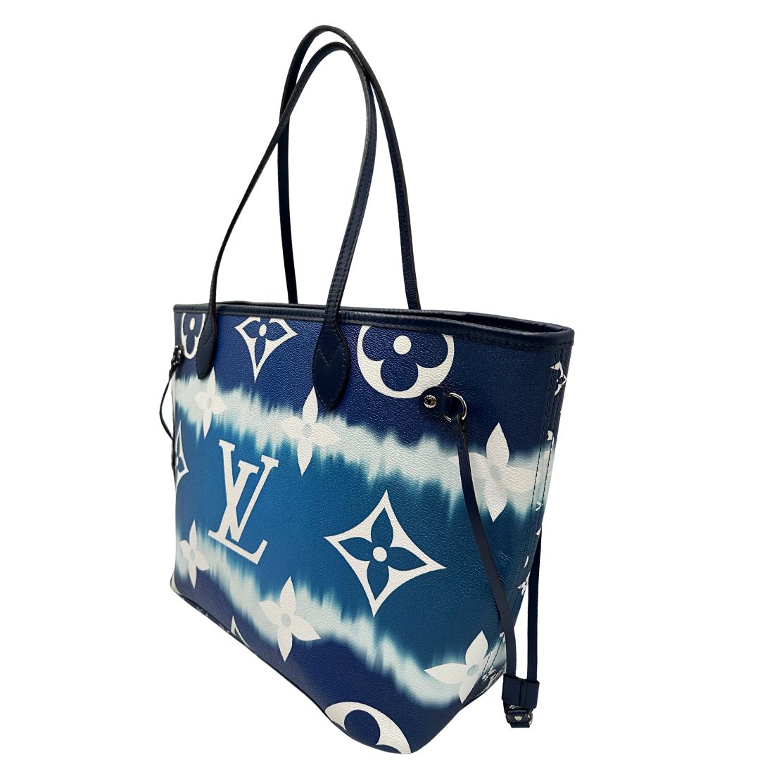 Laterale destro di una borsa Louis Vuitton Neverfull MM in canvas base tie-dye nelle tonalità del blu e bianco, con finiture in pelle blu navy. Da un lato ha stampa Monogram Giant, dall'altra Monogram. Parti metalliche argentate; munita di doppi manici e dustbag, indossabile a spalla.