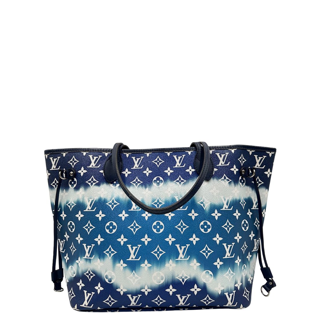 Retro di una borsa Louis Vuitton Neverfull MM in canvas base tie-dye nelle tonalità del blu e bianco, con finiture in pelle blu navy. Da un lato ha stampa Monogram Giant, dall'altra Monogram. Parti metalliche argentate; munita di doppi manici e dustbag, indossabile a spalla.