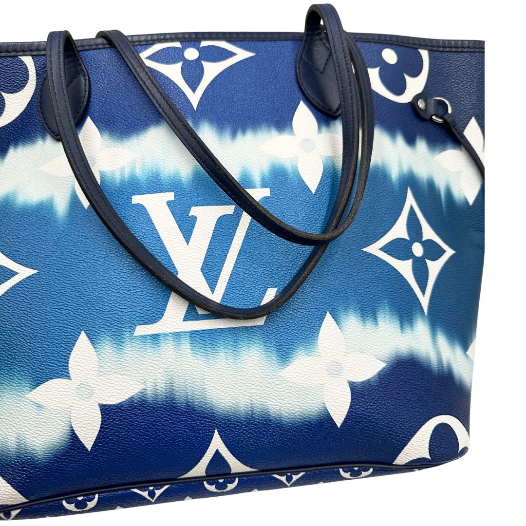 Manici di una borsa Louis Vuitton Neverfull MM in canvas base tie-dye nelle tonalità del blu e bianco, con finiture in pelle blu navy. Da un lato ha stampa Monogram Giant, dall'altra Monogram. Parti metalliche argentate; munita di doppi manici e dustbag, indossabile a spalla.