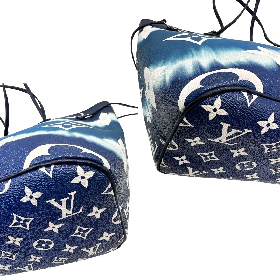 Angoli di una borsa Louis Vuitton Neverfull MM in canvas base tie-dye nelle tonalità del blu e bianco, con finiture in pelle blu navy. Da un lato ha stampa Monogram Giant, dall'altra Monogram. Parti metalliche argentate; munita di doppi manici e dustbag, indossabile a spalla.