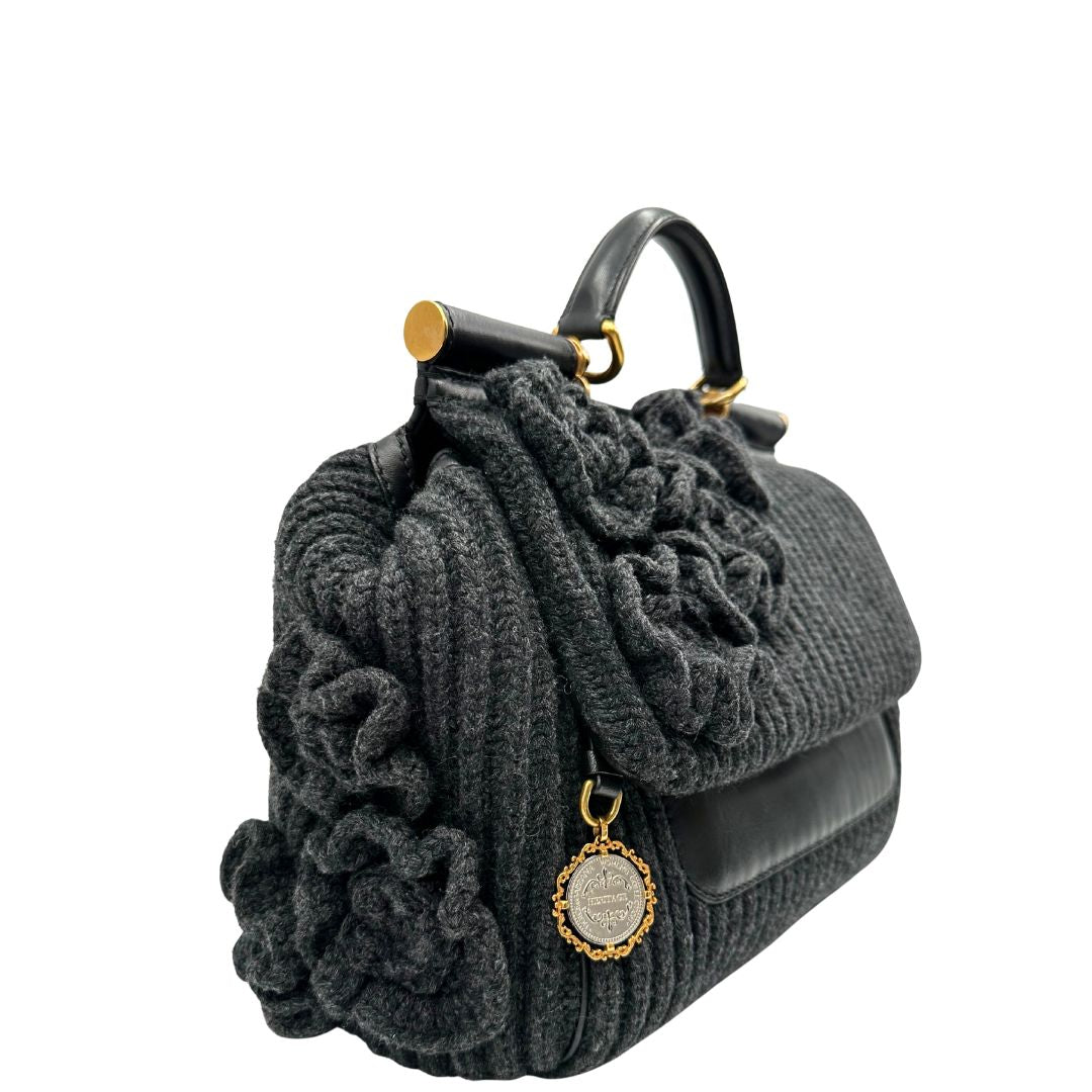 Lato destro di una Borsa D&G Miss Sicily in lana grigia con parti metalliche dorate e finiture in pelle nera e dettagli fiori ; munita di un manico singolo stondato e ciondolo logato. completa di dustbag e card d'autenticità. Originale, usata, di lusso, in ottime condizione.