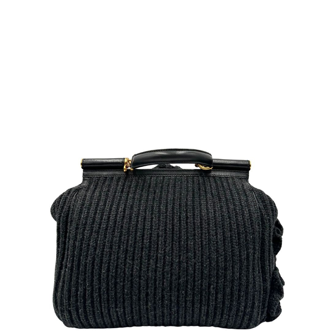 Retro di una Borsa D&G Miss Sicily in lana grigia con parti metalliche dorate e finiture in pelle nera e dettagli fiori ; munita di un manico singolo stondato e ciondolo logato. completa di dustbag e card d'autenticità. Originale, usata, di lusso, in ottime condizione.