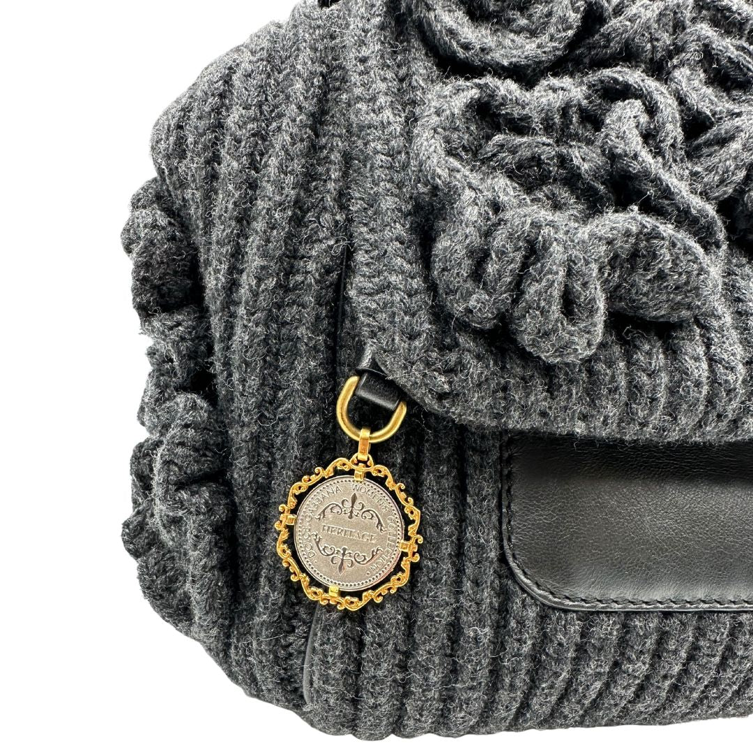 Ciondolo di una Borsa D&G Miss Sicily in lana grigia con parti metalliche dorate e finiture in pelle nera e dettagli fiori ; munita di un manico singolo stondato e ciondolo logato. completa di dustbag e card d'autenticità. Originale, usata, di lusso, in ottime condizione.