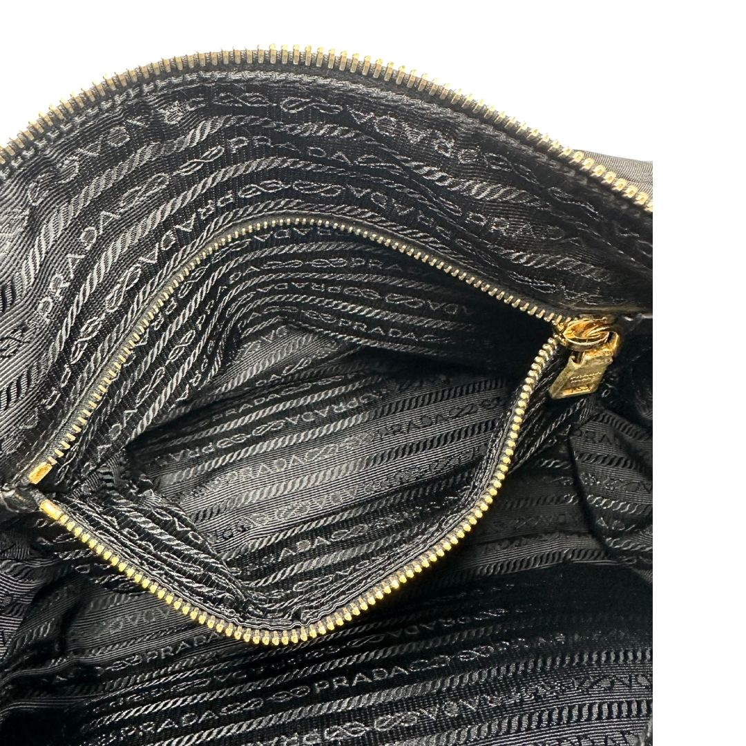 interno Borsa Prada in nylon nero con finiture in pelle tono su tono e parti metalliche dorate; munita di una tracolla regolabile in tessuto. Completa di dustbag, di lusso, originale, ottime condizioni, usata. 
