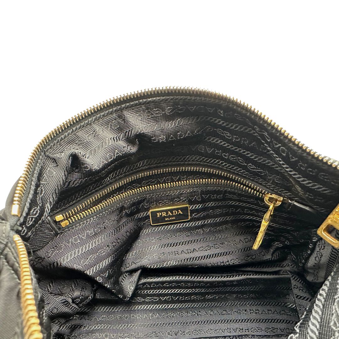 interno Borsa Prada in nylon nero con finiture in pelle tono su tono e parti metalliche dorate; munita di una tracolla regolabile in tessuto. Completa di dustbag, di lusso, originale, ottime condizioni, usata. 