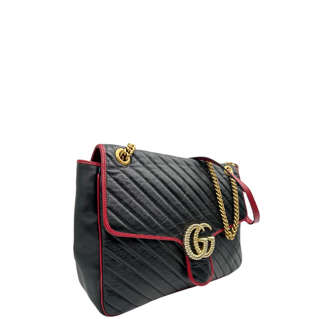 lato Borsa Gucci in pelle nera matelassè con finiture rosse e parti metalliche dorate; munita di una tracolla in catena con spallaccio in pelle. Completa di dustbag, di lusso, originale, ottime condizioni, usata. 