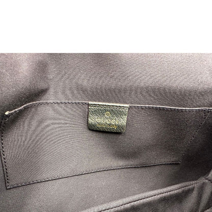 Interno di una borsa Gucci in pelle color oro anticato, dettaglio gioiello circolare sulla patta di chiusura composto da due teste di drago contrapposte, smaltate e decorate con micro strass, parti metalliche dorate; munita di doppi manici in catena a maglie. Indossabile a spalla.