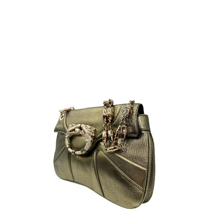 Laterale destro di una borsa Gucci in pelle color oro anticato, dettaglio gioiello circolare sulla patta di chiusura composto da due teste di drago contrapposte, smaltate e decorate con micro strass, parti metalliche dorate; munita di doppi manici in catena a maglie. Indossabile a spalla.