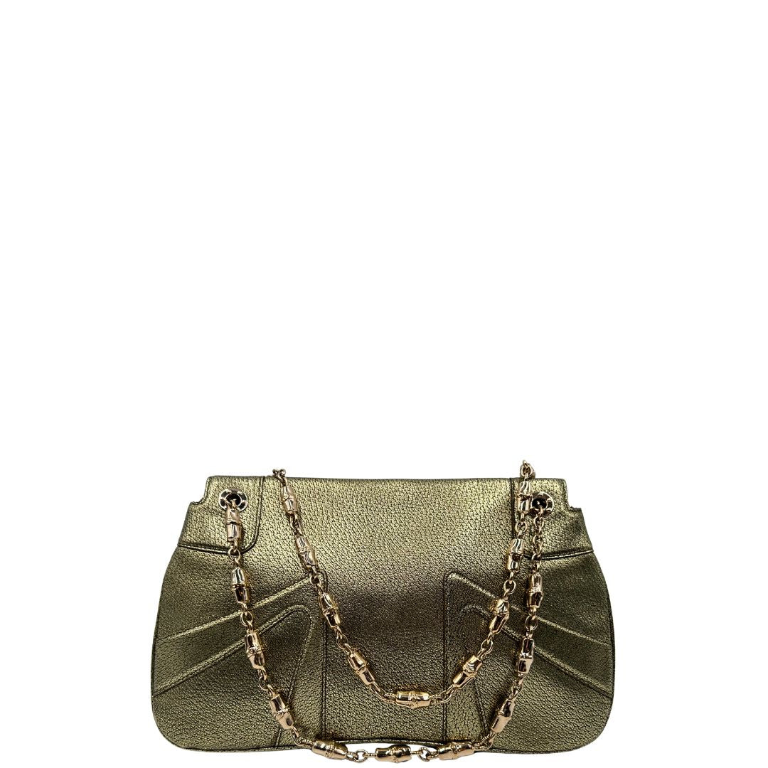 Retro di una borsa Gucci in pelle color oro anticato, dettaglio gioiello circolare sulla patta di chiusura composto da due teste di drago contrapposte, smaltate e decorate con micro strass, parti metalliche dorate; munita di doppi manici in catena a maglie. Indossabile a spalla.