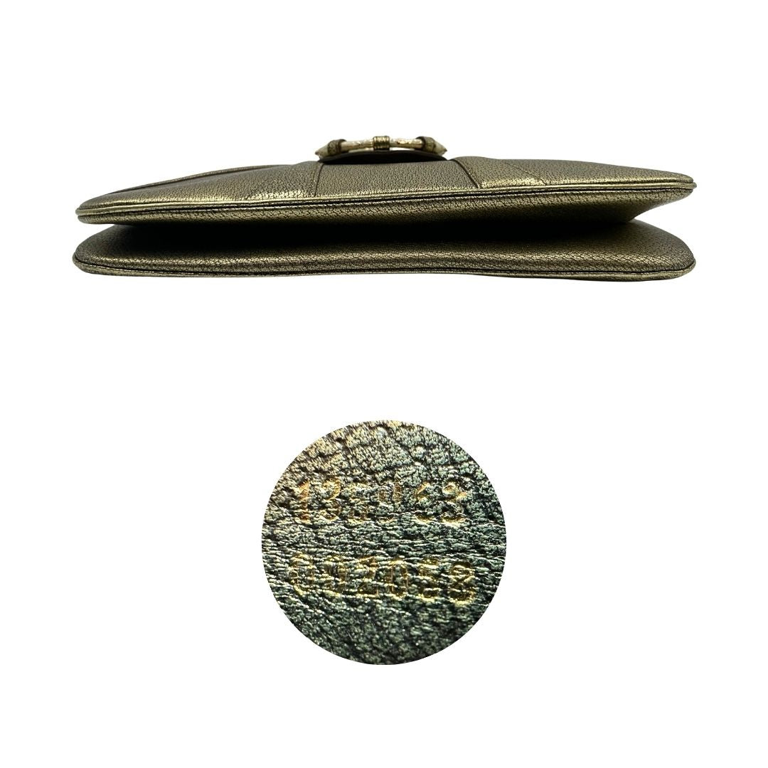 Base e codice di una borsa Gucci in pelle color oro anticato, dettaglio gioiello circolare sulla patta di chiusura composto da due teste di drago contrapposte, smaltate e decorate con micro strass, parti metalliche dorate; munita di doppi manici in catena a maglie. Indossabile a spalla.