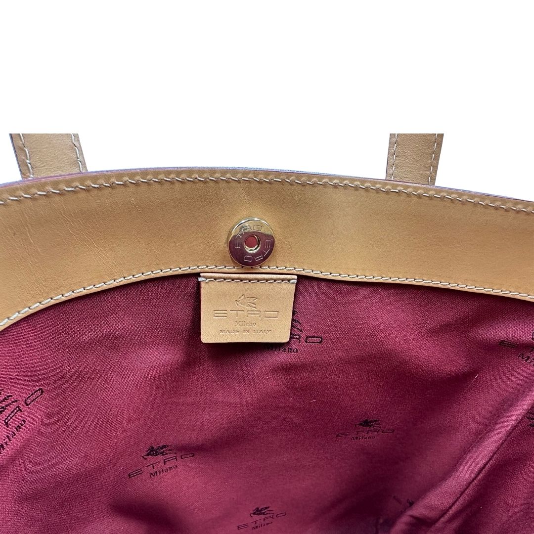 Interno di una borsa Etro in canvas trama paisley in varie tonalità calde e parti in pelle beige, dettagli metallici dorati, munita di doppi manici. Indossabile a mano. Completa di dustbag e charm decorativo amovibile.