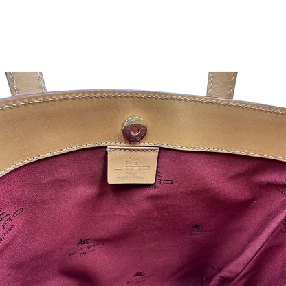 Interno di una borsa Etro in canvas trama paisley in varie tonalità calde e parti in pelle beige, dettagli metallici dorati, munita di doppi manici. Indossabile a mano. Completa di dustbag e charm decorativo amovibile.