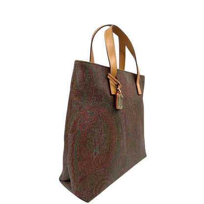 Laterale sinistro di una borsa Etro in canvas trama paisley in varie tonalità calde e parti in pelle beige, dettagli metallici dorati, munita di doppi manici. Indossabile a mano. Completa di dustbag e charm decorativo amovibile.