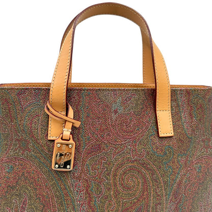 Manici di una borsa Etro in canvas trama paisley in varie tonalità calde e parti in pelle beige, dettagli metallici dorati, munita di doppi manici. Indossabile a mano. Completa di dustbag e charm decorativo amovibile.