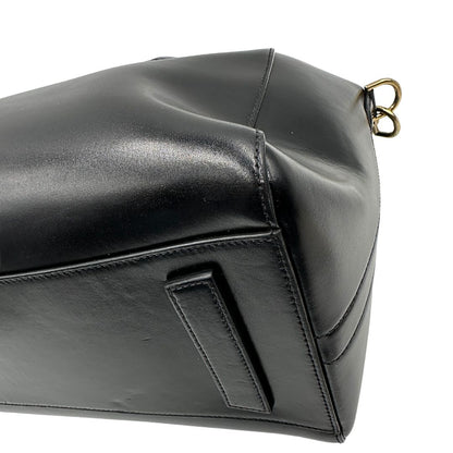 Angoli di una borsa Givenchy Antigona in pelle nera munita di doppi manici stondati, parti metalliche dorate e una tracolla non amovibile e non regolabile.