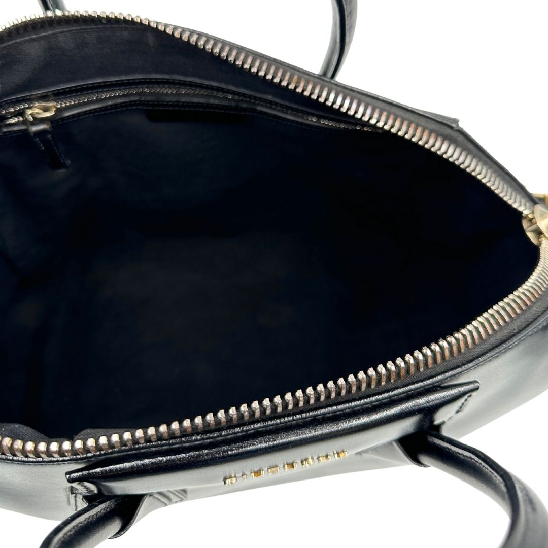 Interno di una borsa Givenchy Antigona in pelle nera munita di doppi manici stondati, parti metalliche dorate e una tracolla non amovibile e non regolabile.