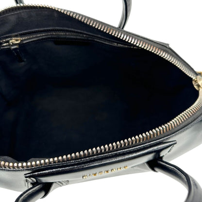 Interno di una borsa Givenchy Antigona in pelle nera munita di doppi manici stondati, parti metalliche dorate e una tracolla non amovibile e non regolabile.