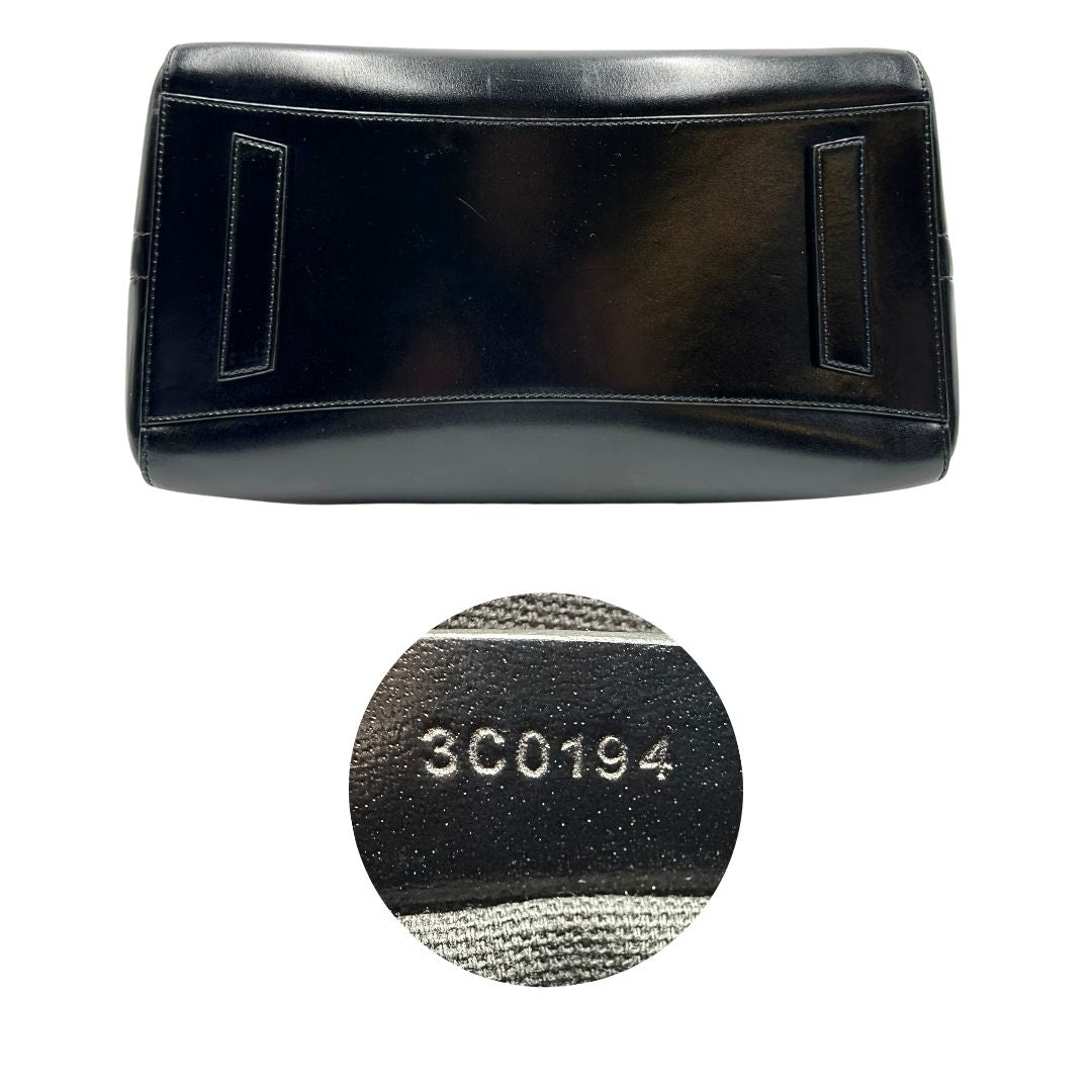 Base e codici di una borsa Givenchy Antigona in pelle nera munita di doppi manici stondati, parti metalliche dorate e una tracolla non amovibile e non regolabile.