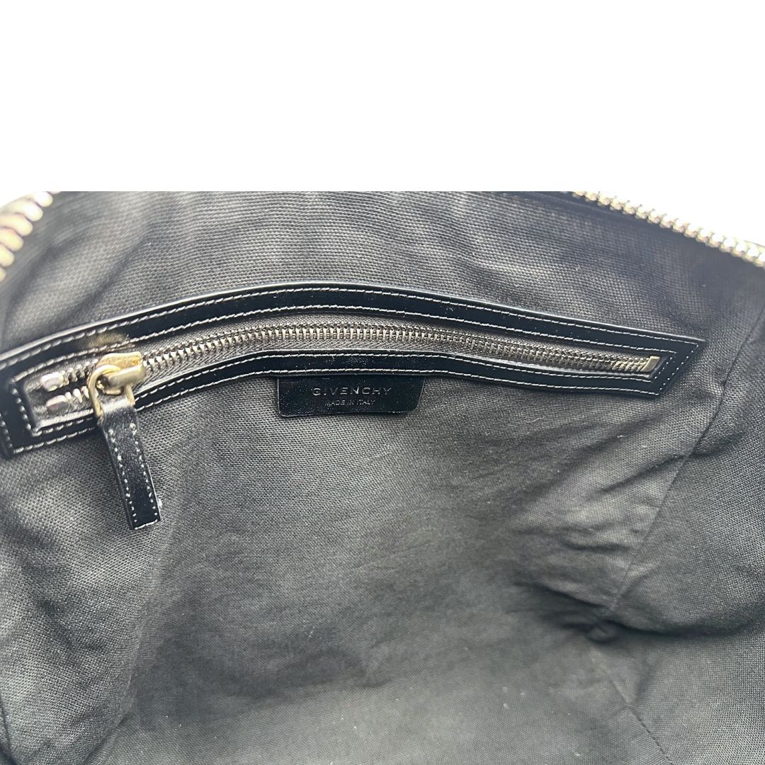 Interno di una borsa Givenchy Antigona in pelle nera munita di doppi manici stondati, parti metalliche dorate e una tracolla non amovibile e non regolabile.