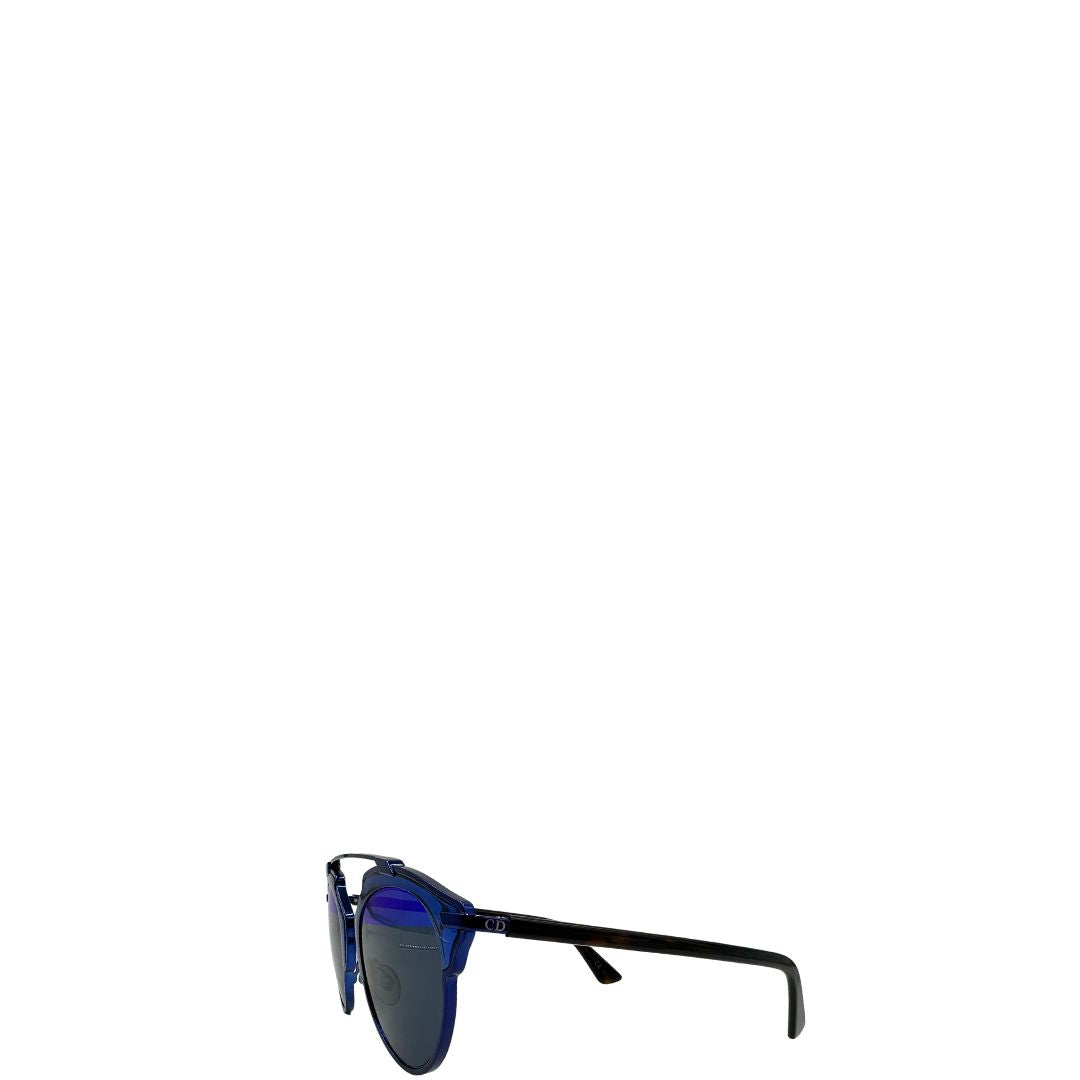 Laterale destro di un paio di occhiali da sole Dior con montatura in metallo blu, ed aste in acetato marroni. Lenti bicolore blu effetto pieno e azzurro effetto specchiato. Completi di corredo.