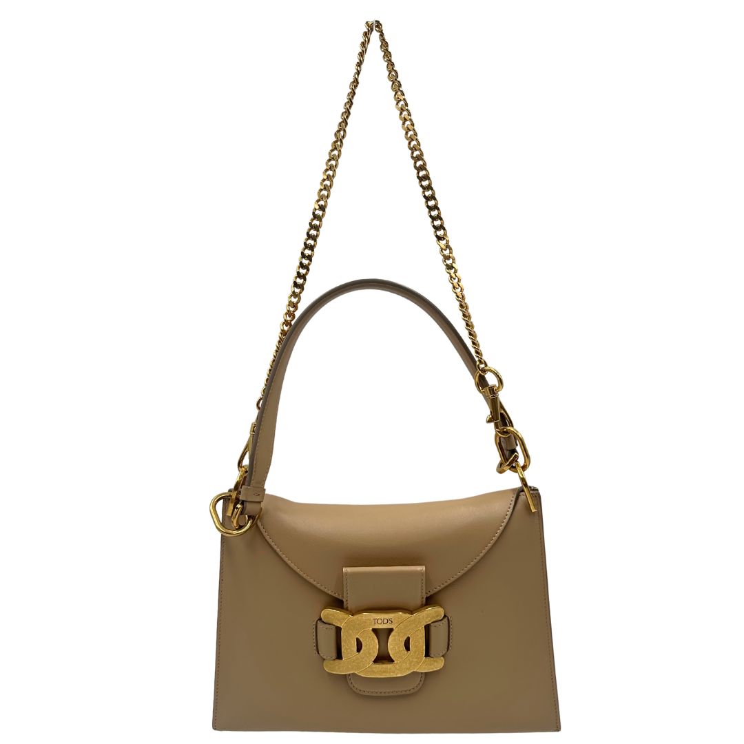 Borsa Tod's in pelle beige con parti metalliche dorate; munita di un manico singolo in pelle e un manico singolo in catena amovibile, indossabile a spalla. Completa di dustbag, di lusso, originale, ottime condizioni.