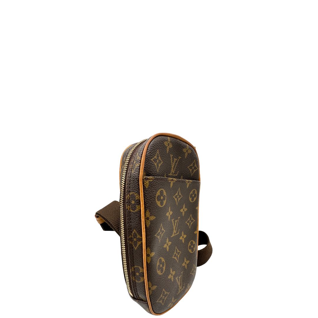 Laterale sinistro di una borsa Louis Vuitton in canvas marrone monogram con finiture in vacchetta naturale e tracolla in tessuto marrone regolabile. Dotata di dustbag.