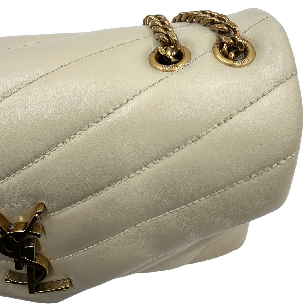 Ritocco con colore di una borsa Saint Laurent in pelle trapuntata bianco latte con tracolla scorrevole in catena e spallacci in pelle, con parti metalliche dorate e iconico logo Cassandre sul front. Completa di dustbag. Indossabile a spalla o a tracolla.