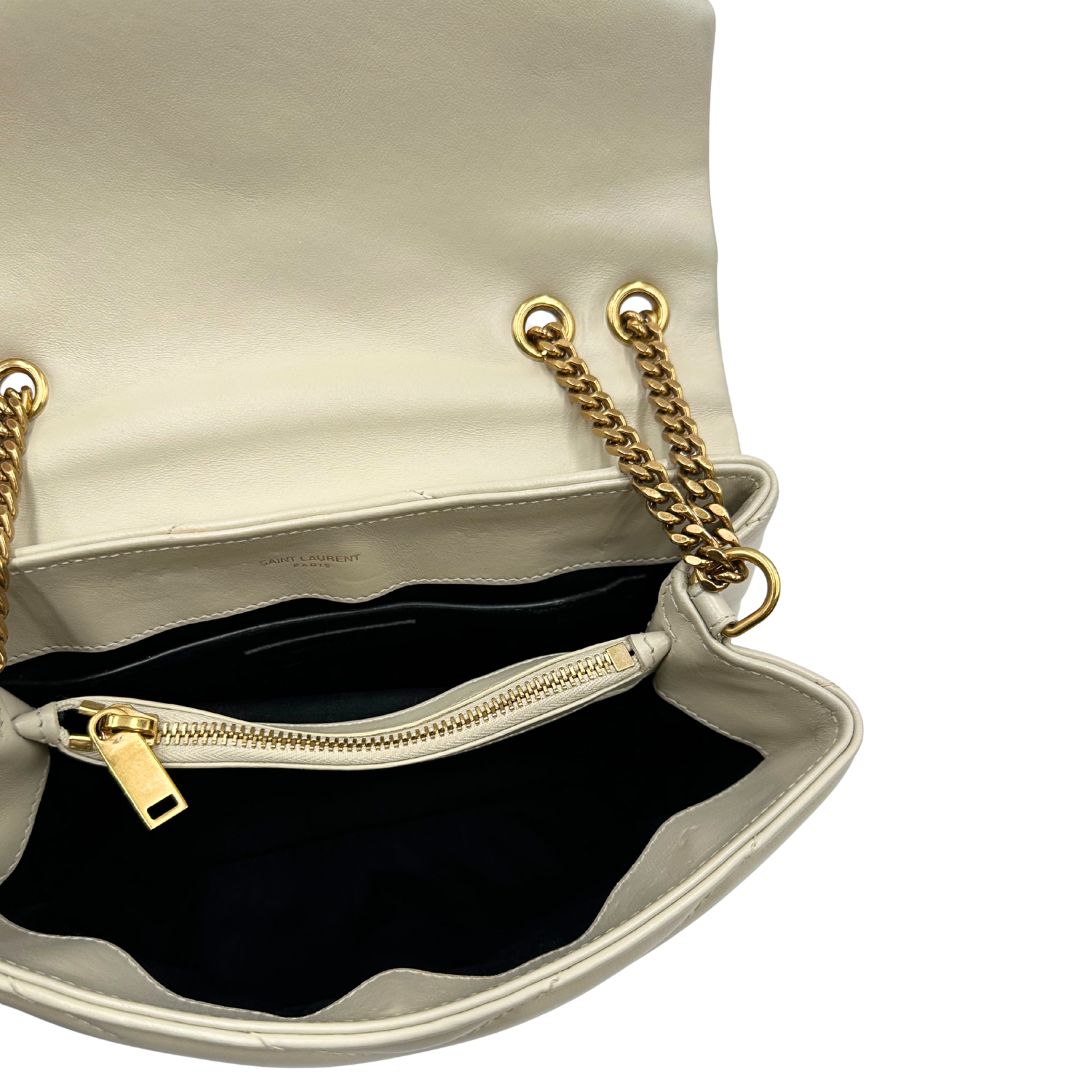 Interno di una borsa Saint Laurent in pelle trapuntata bianco latte con tracolla scorrevole in catena e spallacci in pelle, con parti metalliche dorate e iconico logo Cassandre sul front. Completa di dustbag. Indossabile a spalla o a tracolla.